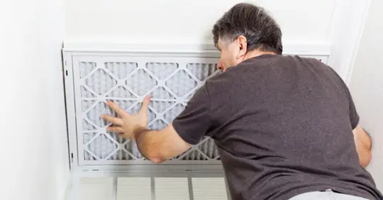 Homeowner replacing air filter